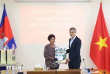 Vietnamese Ambassador Nguyen Minh Vu to Cambodia Nguyen Minh Vu (right) presents Tet gifts to Ha Thi E, who contributed to the resistance war against the US and was awarded a certificate of merit by the Prime Minister of Viet Nam in 2009. (Photo: VNA)