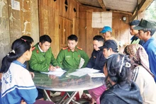 Police officers in Tra Tap Commune, Da Nang City, check the voter list while organising communication activities on election day. (Photo: NDO)