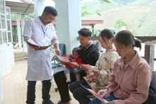 Health workers at Tan Xuan Health Station, Xuan Nha Commune, Son La Province, deliver leaflets on reducing the sex ratio imbalance at birth.