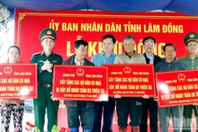 Deputy PM Mai Van Chinh and leaders of ministries, sectors, central agencies, and Lam Dong Province present symbolic boards for the construction of new houses for four families whose houses were completely destroyed by natural disasters.
