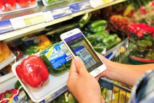 Consumers scan QR codes to check information and origin of goods at a supermarket in Ha Noi. (Photo: NDO)