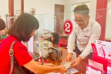 Customers conduct transactions at an Agribank branch. (Photo: HONG ANH/NDO)