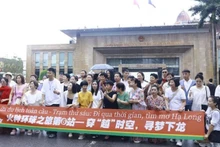 A group of Chinese tourists take photo at the Mong Cai International Border Gate in Quang Ninh Province. (Photo: NDO)