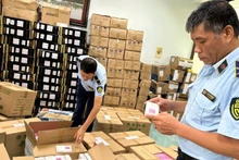 Market management forces in Ha Noi City inspect goods with signs of violations in e-commerce activities. (Photo: HOANG YEN)