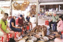 Foreign visitors experience Tan Phong Handicraft Village.