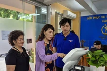 Residents use an AI robot to assist with administrative procedures in Cua Nam Ward, Ha Noi. (Photo: NDO)
