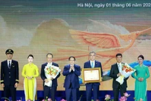 Prime Minister Pham Minh Chinh awards a certificate of merit to Viet Nam Airlines. (Photo: VNA)