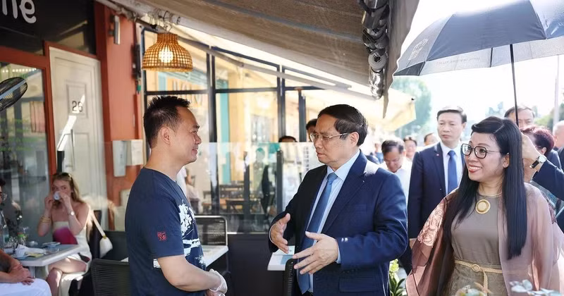 PM Pham Minh Chinh (centre) and his spouse visit the family of Vo Ba Luan - the owner of a restaurant in Nice. (Photo: VNA)