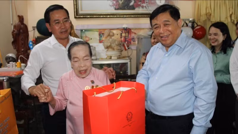 Deputy Prime Minister Nguyen Chi Dung visits and presents gifts to Labour Hero Ho Thi Luom. (Photo: Nguyen Trung)