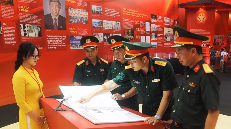 Delegation of officers and soldiers of Division 3 (Military Region 1) experience reading e-books at the exhibition. (Photo: Nhan Dan Newspaper)