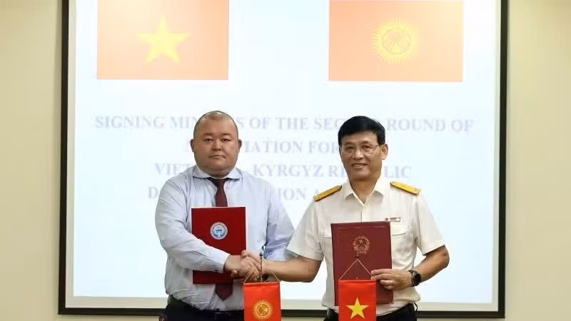 Deputy Director General Dang Ngoc Minh and Ruslan Tynaliev, Head of the Customs Policy Department under Kyrgyzstan’s Ministry of Economy and Commerce, sign the document.