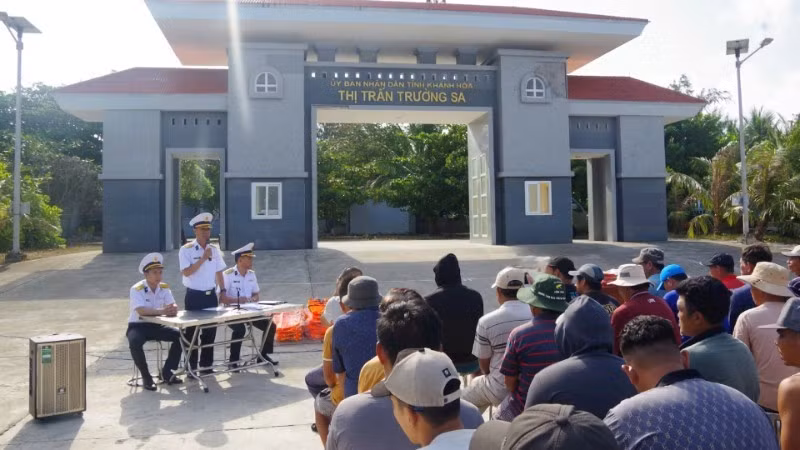 Officers from the Truong Sa Technical Logistics Service Centre informs fishermen about Government Directive 45 and the operations of boat shelters and fishing villages in the Truong Sa (Spratly) Archipelago. (Photo: Duc Thuan)