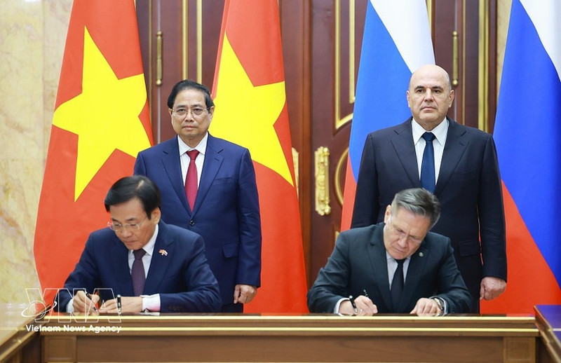 Vietnamese PM Pham Minh Chinh (standing, left) and his Russian counterpart Mikhail Mishustin (standing, right) witness the signing of the agreement between the two governments on cooperation in building a nuclear power plant on the territory of Viet Nam. (Photo: VNA)