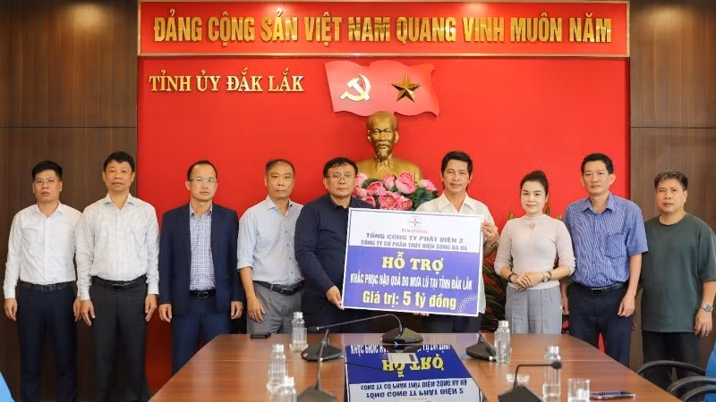 The working delegation presents a symbolic cheque for the relief funding to representatives of Dak Lak Province.