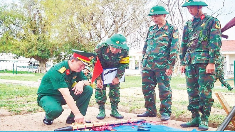 Colonel Nguyen Thanh Tam, Commander of the Tay Ninh Provincial Military Command, inspects the explosive charge wrapping before the 2025 live demolition drill.