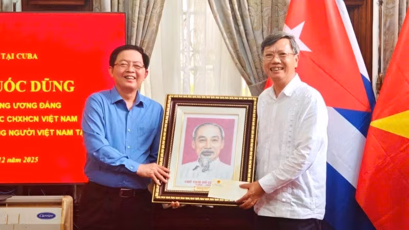Deputy Prime Minister Ho Quoc Dung presents a portrait of President Ho Chi Minh to Ambassador Le Quang Long and staff of the Embassy. (Photo: Viet Nam Embassy in Cuba)
