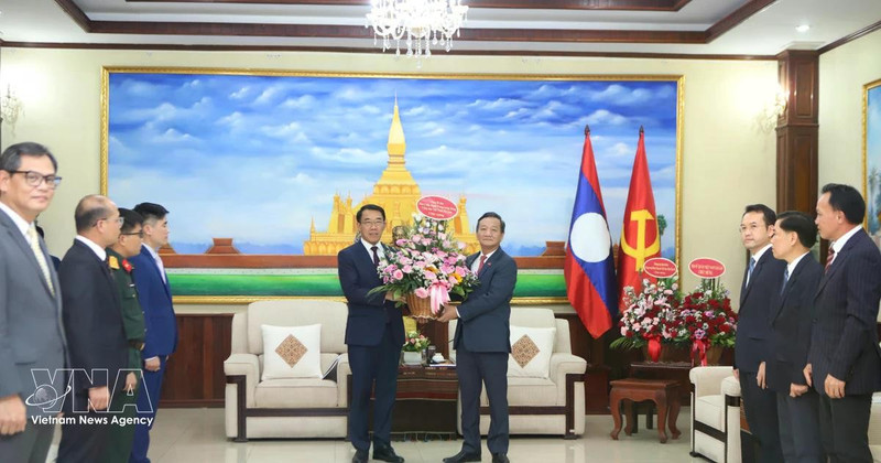 Ambassador Nguyen Minh Tam presents Party General Secretary To Lam's flowers to the LPRP Central Committee's External Relations Commission to congratulate on the LPRP's 71st founding anniversary. (Photo: VNA)