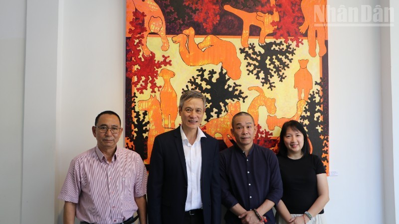 Vietnamese Ambassador to Cambodia Nguyen Minh Vu (in a black suit) attends the exhibition of painter Bui Hoang Duong (in a black shirt). (Photo: HUY VU)