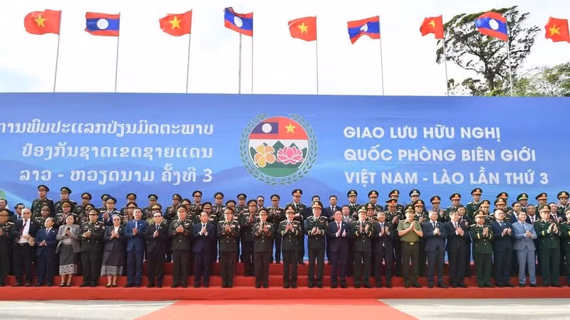 General Phan Van Giang and General Khamliang Outhakaysone pose for a group photograph with members of both delegations at Thanh Thuy Border Gate.