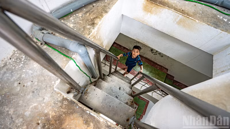 Inside the tower, visitors continue their ascent via steep steel staircases weathered by time, leading to the highest viewing platform of the structure.