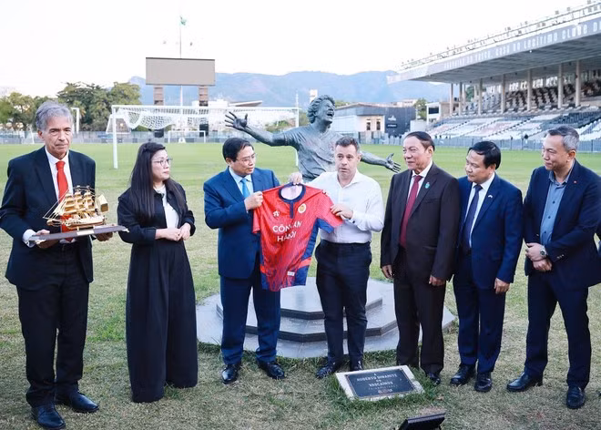PM Pham Minh Chinh (3rd from left) presents a jersey of the Ha Noi Football Club to the Vasco da Gama Football Club's representative. (Photo: VNA)