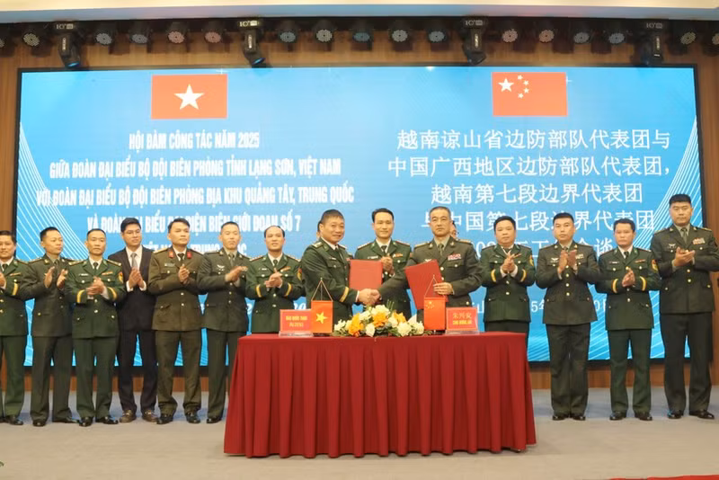 The heads of the two delegations sign the minutes of the talks on December 30. (Photo: VNA)