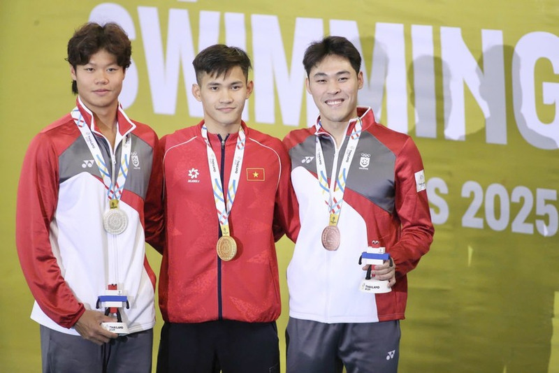 Swimmer Pham Thanh Bao (centre) of Viet Nam successfully defends his SEA Games title in the men’s 200m breaststroke, touching home first in the final with a time of 2 minutes 12.81 seconds. (Photo: VNA)