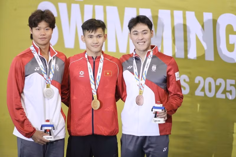Swimmer Pham Thanh Bao (centre) of Viet Nam successfully defends his SEA Games title in the men’s 200m breaststroke, touching home first in the final with a time of 2 minutes 12.81 seconds. (Photo: VNA)