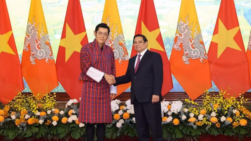 Prime Minister Pham Minh Chinh (R) welcomes King of Bhutan Jigme Khesar Namgyel Wangchuck in Ha Noi on August 19. (Photo: NDO)