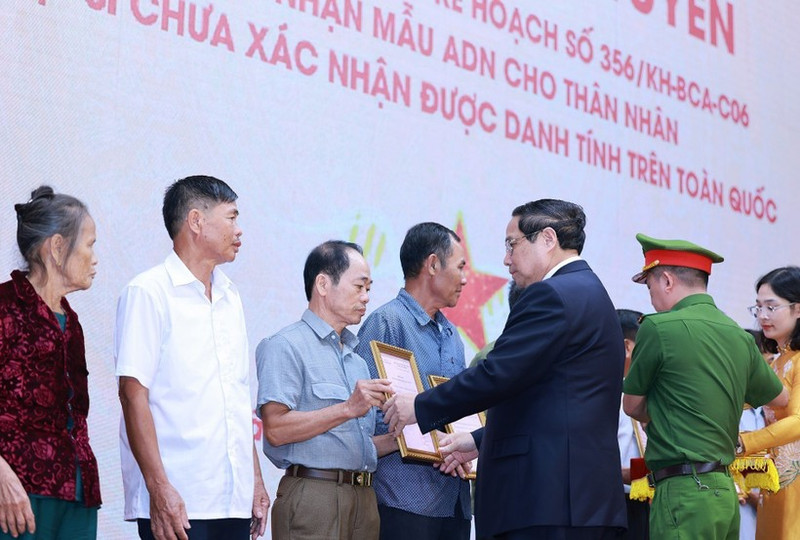 PM Pham Minh Chinh presents the announcements of martyrs' DNA testing results to representatives of families at the conference on July 25. (Photo: VNA)