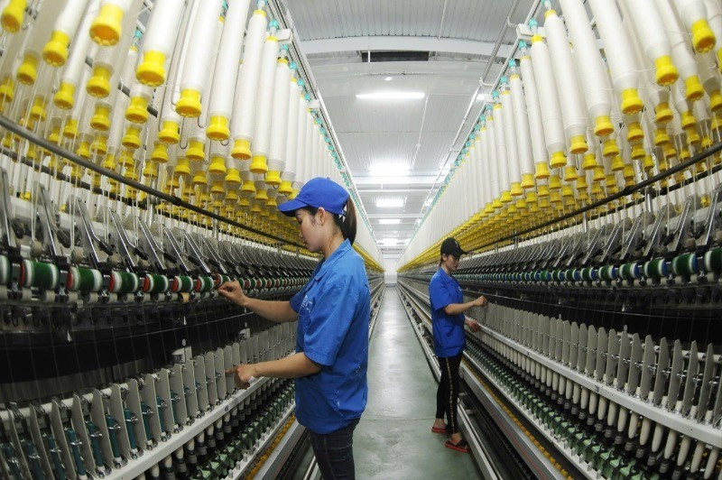 Workers at 8-3 Textile One-Member Co., Ltd. operating a yarn production line. (Photo: TRAN HAI)