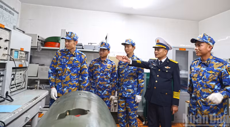 Colonel Nguyen Dinh Manh, Political Commissar of Brigade 170, inspects technical support work in the control room of Station A3.