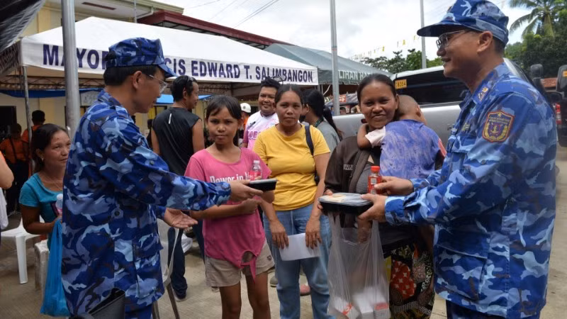 Vietnam Coast Guard officers directly deliver food portions to residents affected by the earthquake in Bogo Province, the Philippines.