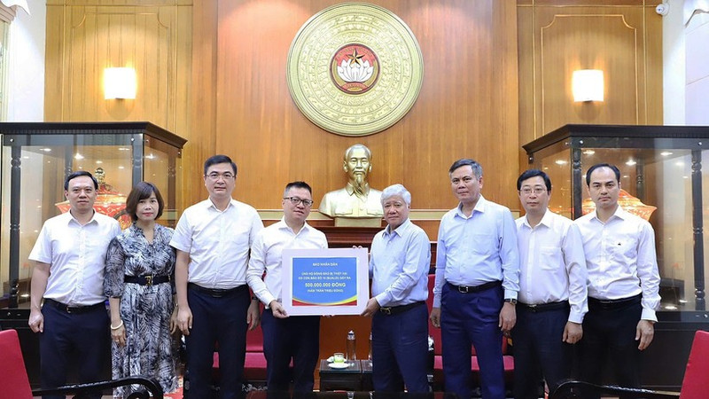 Do Van Chien (4th from right) receives the donation from the leaders, cadres, and employees of Nhan Dan Newspaper. (Photo: NDO)