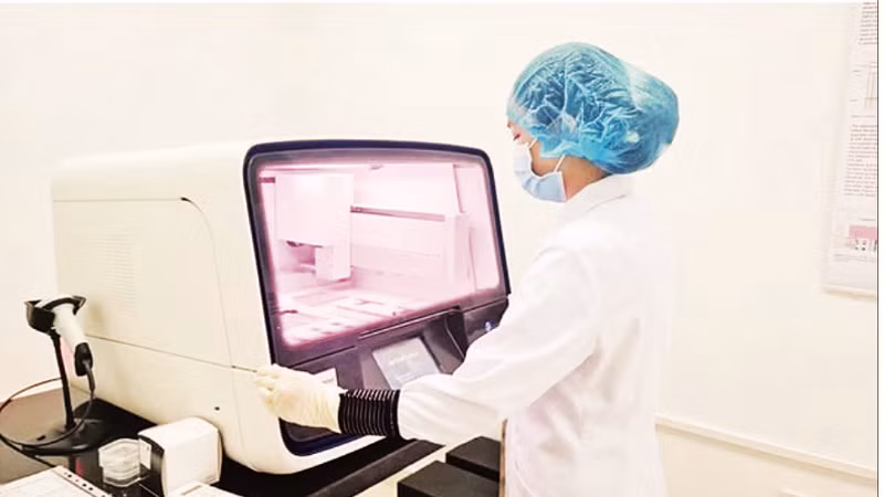 An appraiser of a DNA Examination Centre analyses a sample of martyrs' remains. (Photo: NDO)