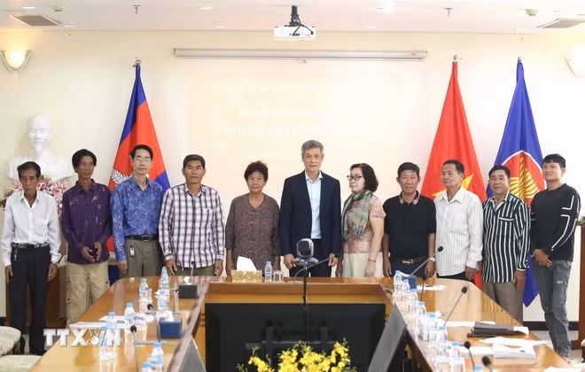 Ambassador Nguyen Minh Vu (centre) and 10 individuals and family members of Vietnamese expatriates in Cambodia who contributed to the revolution throughout various periods participate in the programme. (Photo: VNA)
