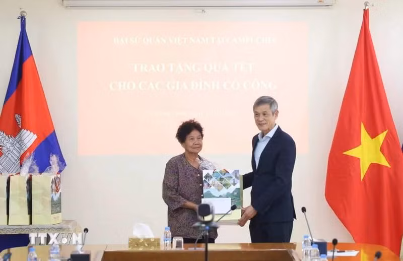 Vietnamese Ambassador Nguyen Minh Vu to Cambodia Nguyen Minh Vu (right) presents Tet gifts to Ha Thi E, who contributed to the resistance war against the US and was awarded a certificate of merit by the Prime Minister of Viet Nam in 2009. (Photo: VNA)