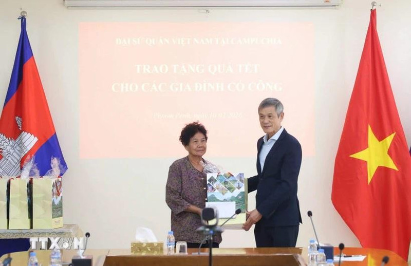 Vietnamese Ambassador Nguyen Minh Vu to Cambodia Nguyen Minh Vu (right) presents Tet gifts to Ha Thi E, who contributed to the resistance war against the US and was awarded a certificate of merit by the Prime Minister of Viet Nam in 2009. (Photo: VNA)