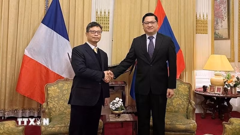 Ambassador Trinh Duc Hai extends New Year wishes of good health, peace and success to Lao Ambassador Kalamoungkhoune Souphanouvong, as well as to all officials and staff of both embassies and their families. (Photo: VNA)