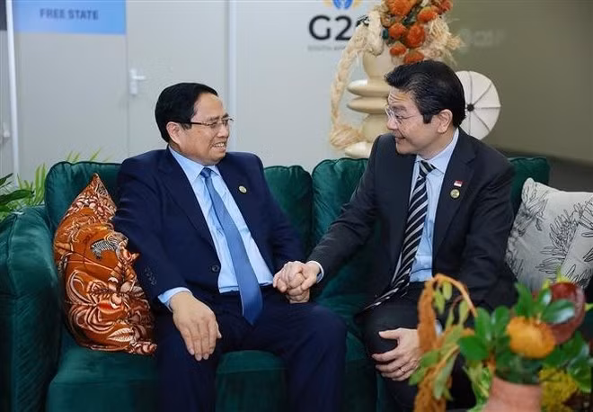 Vietnamese Prime Minister Pham Minh Chinh (L) and his Singaporean counterpart Lawrence Wong in Johannesburg on November 23. (Photo: VNA)