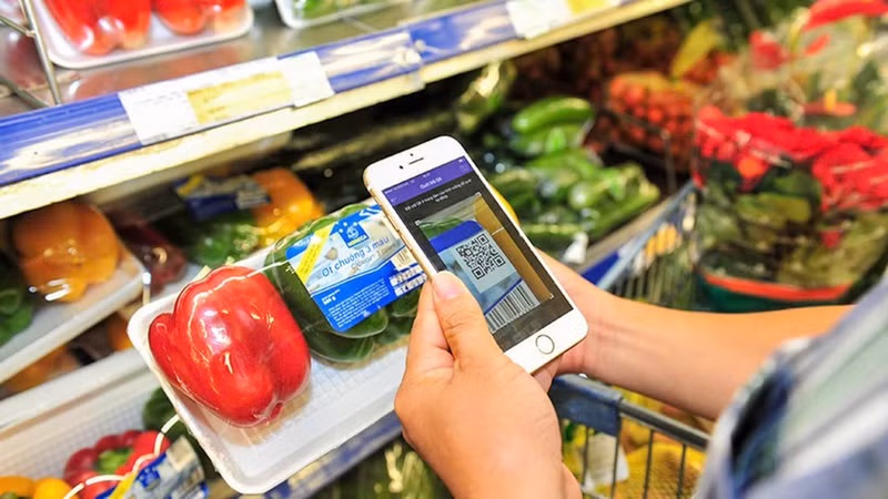 Consumers scan QR codes to check information and origin of goods at a supermarket in Ha Noi. (Photo: NDO)
