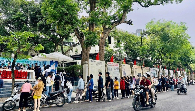 During the campaign celebrating the 135th anniversary of President Ho Chi Minh's birthday, many Gen Z readers lined up to receive a special publication of Nhan Dan Newspaper. (Photo: NDO)