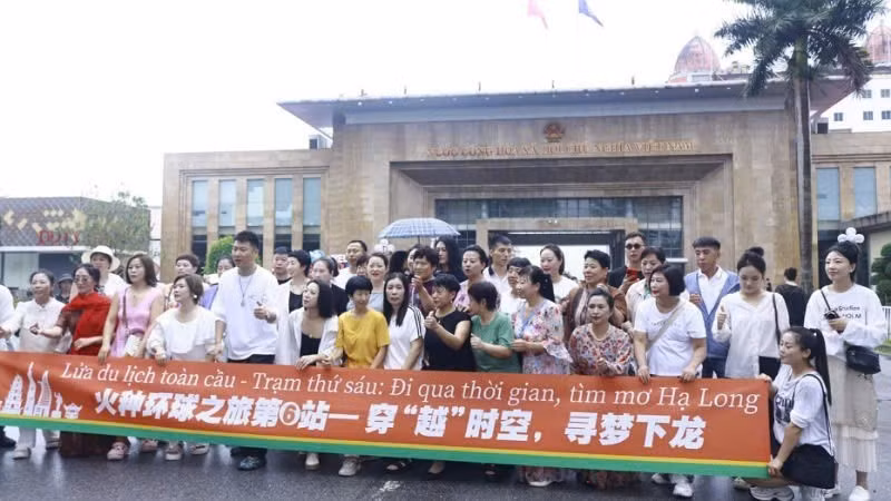A group of Chinese tourists take photo at the Mong Cai International Border Gate in Quang Ninh Province. (Photo: NDO)