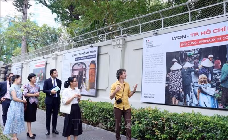 Adrien Jean (right) introduces his photos at the exhibition (Photo: VNA)