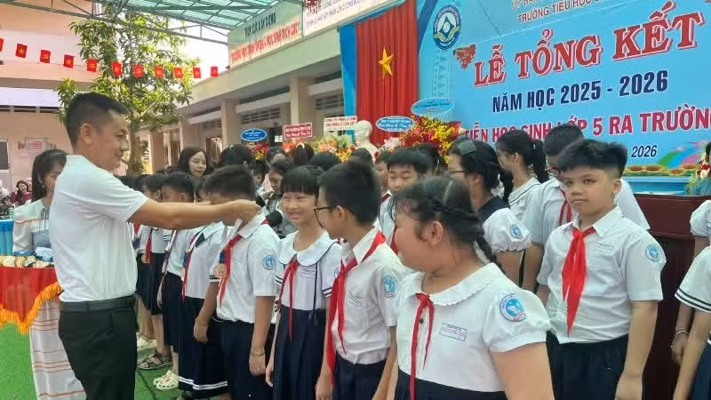Nguyen Van Bao, Director of Co.opmart Tay Ninh, presents commemorative gifts and new notebooks to pupils.