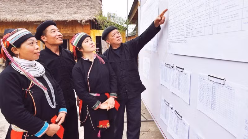Voters review the list of candidates publicly posted at the cultural house of Nam Dam Hamlet, Quan Ba Commune (Tuyen Quang Province) (Photo: VNA)
