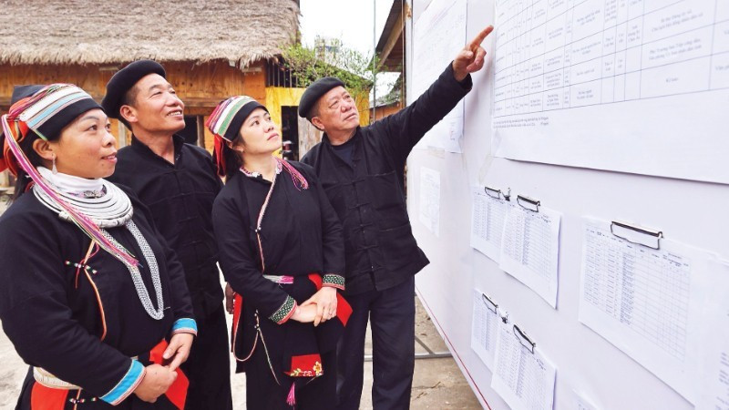 Voters review the list of candidates publicly posted at the cultural house of Nam Dam Hamlet, Quan Ba Commune (Tuyen Quang Province) (Photo: VNA)