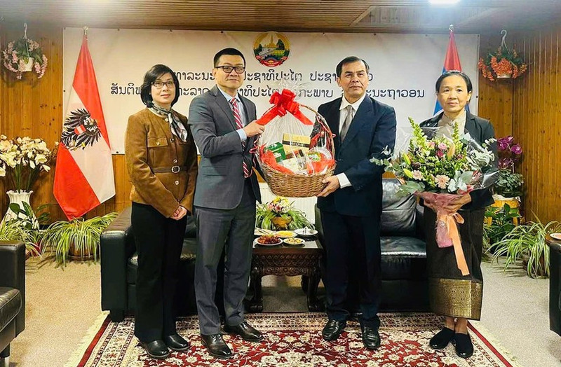 Vietnamese Ambassador Vu Le Thai Hoang congratulates Lao Ambassador Khampheng Douangthongla. (Photo: NDO)