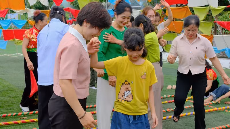 Children and their parents enjoy activities in the kite tent area of the programme. (Photo: nhandan.vn)