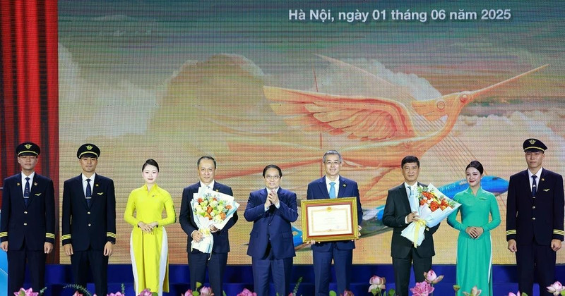 Prime Minister Pham Minh Chinh awards a certificate of merit to Viet Nam Airlines. (Photo: VNA)